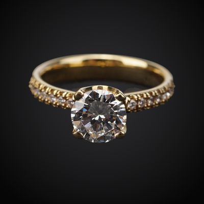 une bague de fiançailles en or sertie d'un diamant blanc sur fond noir