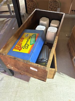 une caisse en bois remplie de boîtes et une boîte de papier toilette