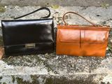 two leather bags sitting on the ground next to each other
