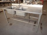 deux éviers au milieu d'une grande pièce équipée de tables et de chaises