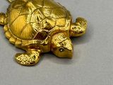 une tortue dorée allongée sur une table