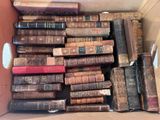 une boîte pleine de vieux livres posée sur le sol