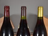 three bottles of wine sitting in a wooden box