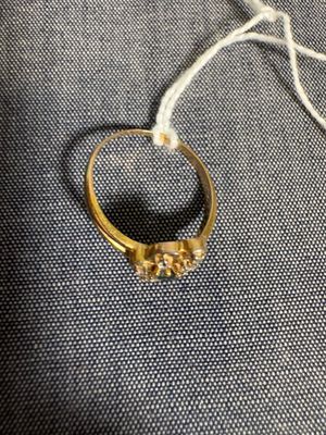 un gros plan d'une bague en or posée sur un tissu bleu