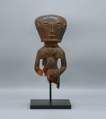 une sculpture en bois représentant un homme tenant un oiseau sur un socle