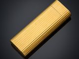 a gold lighter sitting on top of a black surface