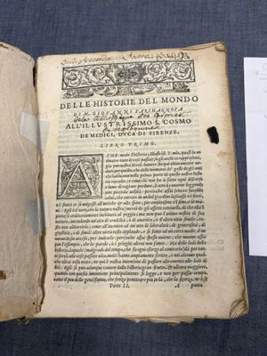 un livre ouvert sur lequel se trouve une feuille de papier