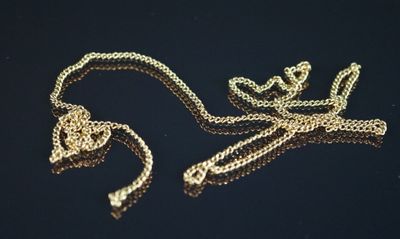 a gold chain that is laying on a black surface