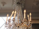 un lustre dans une pièce où est accroché un tableau au mur