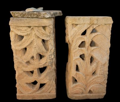 pair of carved stone vases on a black background with a black background