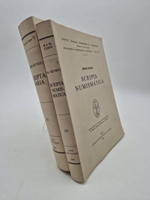 trois livres sont empilés sur une surface blanche