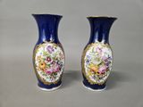 two blue vases with flowers on them on a table