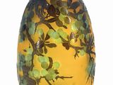a yellow vase with green flowers on it on a white background