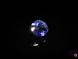 a close up of a blue sapphire stone on a black surface