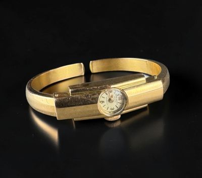 an image of a close up of a gold bracelet with a clock on it