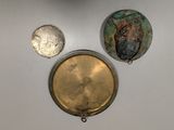 three pieces of metal are displayed on a white surface