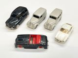 plusieurs petites voitures sont alignées sur une surface blanche