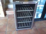 a wine cooler sitting on the floor in a kitchen