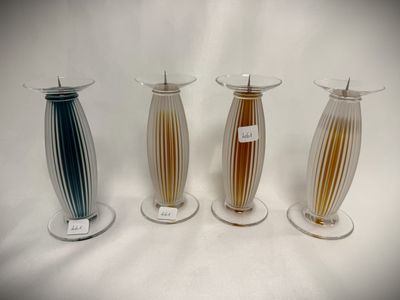 four different colored vases are lined up on a white surface