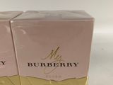 two boxes of burberry perfume sitting on top of a white surface