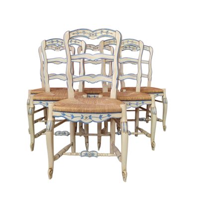 four wooden chairs with blue and white designs on them sitting next to each other