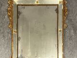a mirror hanging on the wall with a gold frame