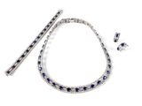 une photo d'un ensemble composé d'un collier, d'un bracelet et de boucles d'oreilles sertis de saphirs