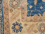 an image of a blue and tan area rug on the ground