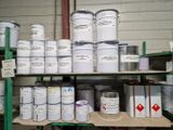 de nombreux pots de peinture posés sur une étagère dans un garage