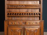 an antique oak dresser with carved doors and drawers