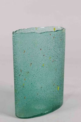a green glass vase with a yellow speckle on it