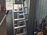 a ladder that is leaning against a wall next to a chair