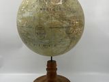 an old globe on a wooden stand on a white background