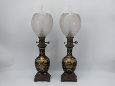 une paire de vases noirs et dorés ornés de fleurs blanches