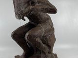 statue représentant un homme assis sur un rocher, les mains posées sur les genoux