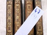 Plusieurs vieux livres sont posés sur une table, accompagnés d'une étiquette de prix