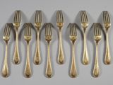 six forks are lined up in a row on a white surface