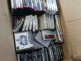 a cardboard box filled with many dvds and games