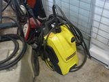 un compresseur jaune et noir et des tuyaux dans une pièce