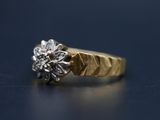 Gros plan sur une bague en or ornée d'une fleur
