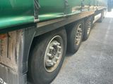 a green semi truck that is parked on the side of the road