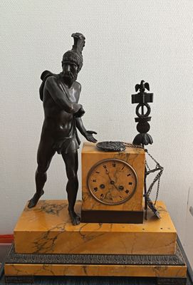 a statue of a man with a clock on a table