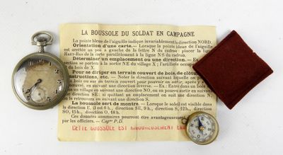 une petite montre de poche et une petite montre de poche posées sur un morceau de papier