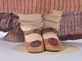 a woman ' s feet in a pair of brown shoes