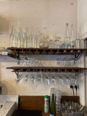 many empty wine glasses on the shelves in the kitchen