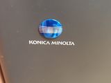 un gros plan d'un ordinateur portable portant le logo Konica