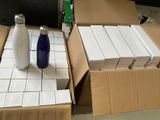 two bottles of milk sitting on a table next to boxes of boxes
