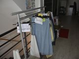a rack of clothes hanging on a rail in a room