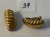 paire de boucles d'oreilles dorées présentant un motif torsadé sur fond blanc