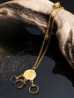 un gros plan d'un collier en or posé sur un morceau de bois